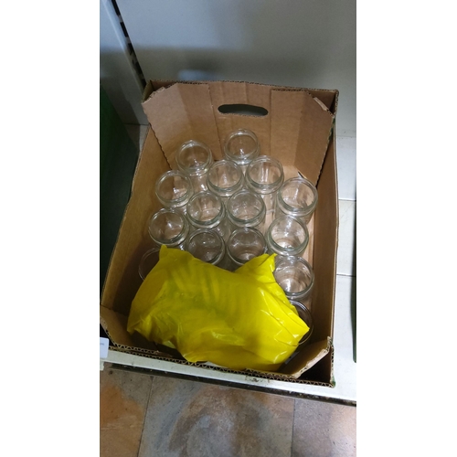 134 - Boxed lot of clear glass jars. Includes a sealed yellow bag of unknown contents.