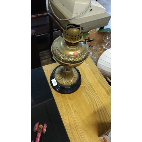 181 - Brass oil lamp base with ornate embossed detailing, fluted pedestal base, and black circular foot.