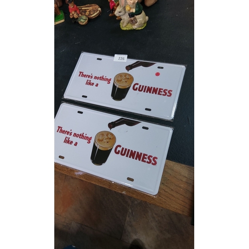 226 - Pair of vintage-style Guinness tin license plates featuring classic advertising design.