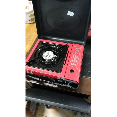 257 - Portable single-burner gas stove in red with carrying case, featuring an adjustable flame control an... 