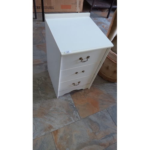 284 - White wooden three-drawer bedside cabinet with brass handles and a gallery back