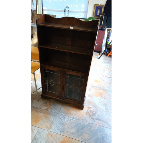 288 - Vintage oak bookcase with leaded glass cabinet doors. It features open shelving and a scalloped top.