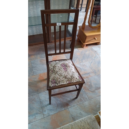 292 - Early 20th-century wooden bedroom chair with a slatted back and glass panel. Features a floral uphol... 