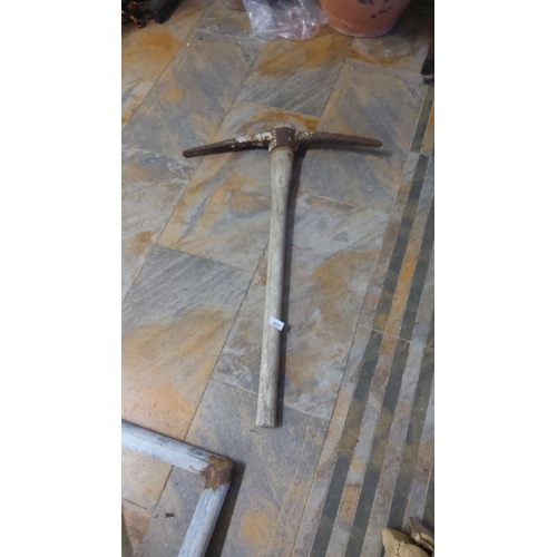 379 - Vintage iron pickaxe with a weathered wooden handle.