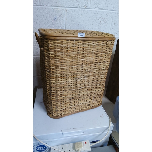 407 - Vintage wicker laundry basket with hinged lid and side handles. Sturdy woven construction with a nat... 