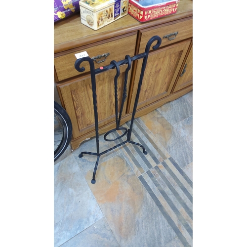 417 - Wrought iron fireplace tool stand with twisted detailing and tongs. Features sturdy construction wit... 