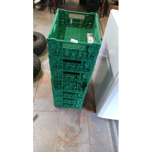 467 - Stack of seven green plastic collapsible storage crates. The crates feature a practical and space-sa... 