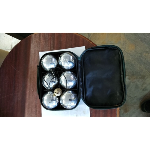 157 - Set of six metal boules with a wooden jack and measuring string, housed in a zippered carrying case.