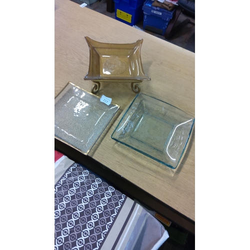 217 - Trio of decorative glass bowls includes a gold-rimmed textured glass plate, a clear square dish, and... 