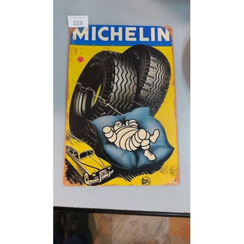 223 - Michelin tin sign featuring the iconic Bibendum mascot, with bold colors and classic automotive adve... 