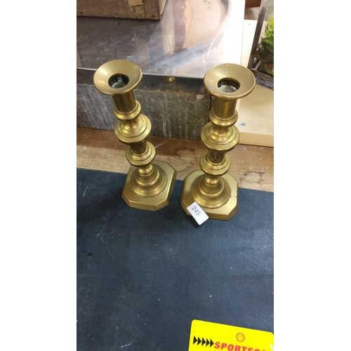 245 - Pair of vintage brass candlesticks with a classic tiered design and octagonal bases.