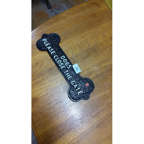 292 - Black cast iron sign shaped like a dog bone with 