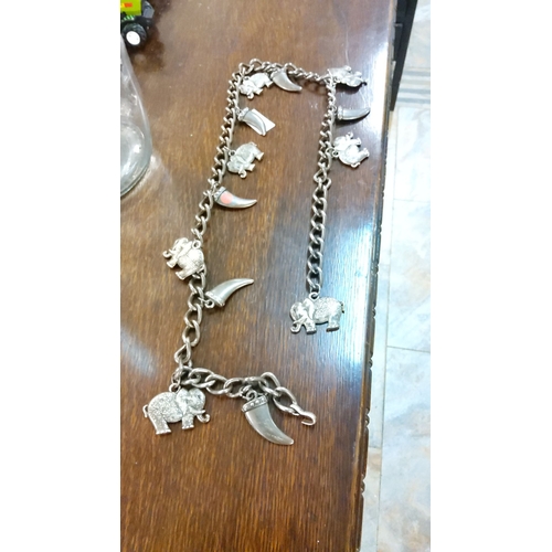 313 - Silver-tone charm belt featuring elephant and claw-shaped charms with a sturdy chain-link design and... 