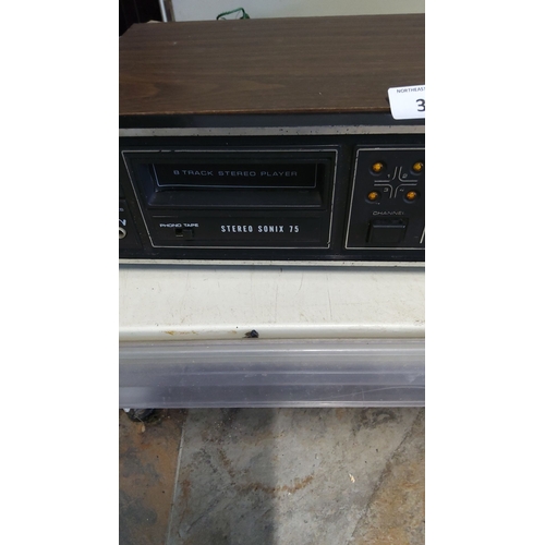 33 - Vintage Stereo Sonix 75 8-Track Player features a classic woodgrain design with manual controls.(w)