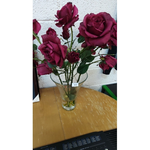 352 - Artificial burgundy rose bouquet in a clear glass vase.