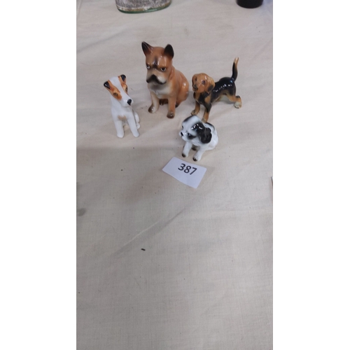 387 - Set of four vintage ceramic dog figurines, finely painted with charming expressions.