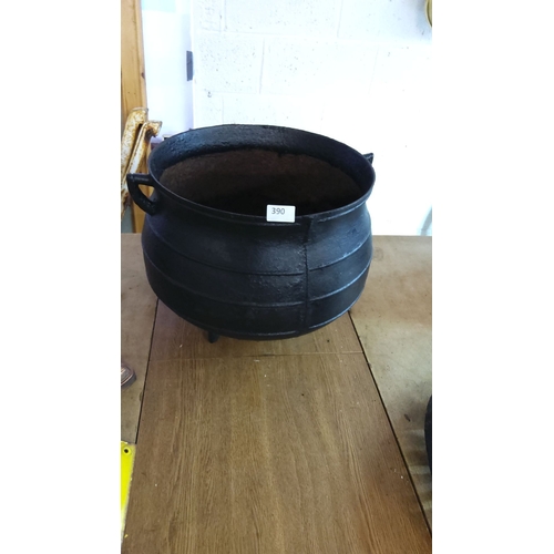 390 - Large antique cast iron cauldron with three feet and side handles.