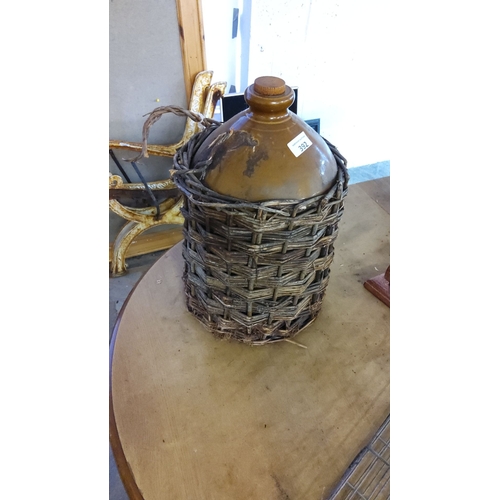 392 - Vintage brown glazed stoneware flagon with original woven wicker casing and handle.