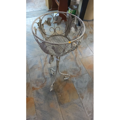 400 - Vintage wrought iron plant stand with ornate grapevine detailing, a woven metal base, and scrolled t... 