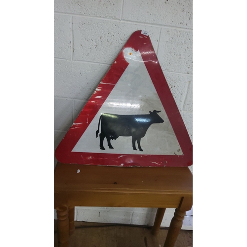 402 - Vintage metal cattle warning road sign features a bold black silhouette on a reflective red and whit... 