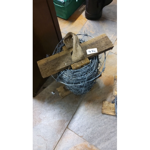 474 - Roll of barbed wire with wooden supports and fabric handle.