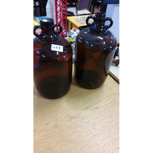 497 - Pair of vintage glass demijohn bottles with double-loop handles. One with original cap, the other op... 