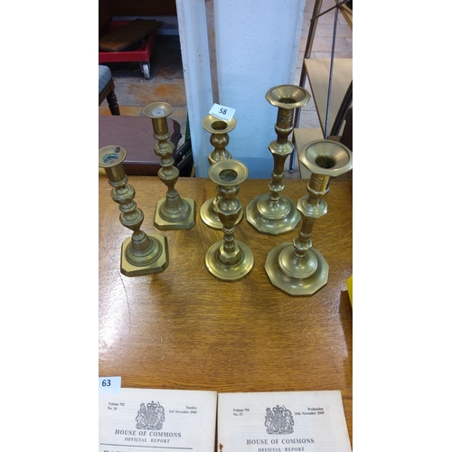 58 - A collection of six vintage brass candlesticks, varied in design with hexagonal and round bases.