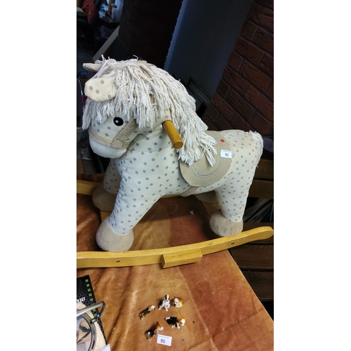 91 - Fabric rocking horse with wooden handles and base, featuring a polka-dot pattern and plush details.