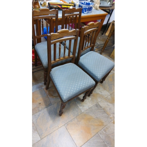 97 - Set of four vintage wooden dining chairs with turned spindle backs and blue upholstered seats.