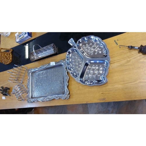 203 - Mixed lot of silver-plated tableware, including ornate serving trays, toast racks, and cutlery holde... 