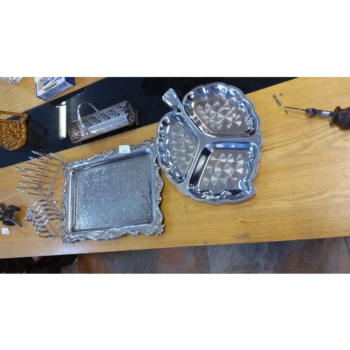 203 - Mixed lot of silver-plated tableware, including ornate serving trays, toast racks, and cutlery holde... 