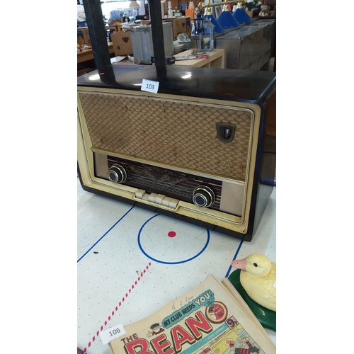 103 - Mid-20th century vintage tube radio with woven speaker grille and dual tuning dials. Features elegan... 