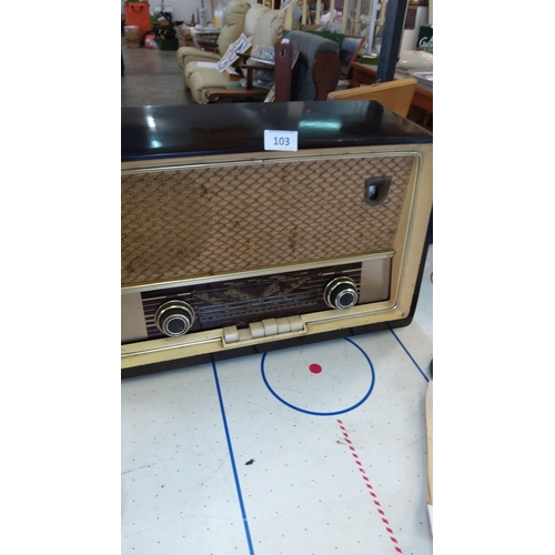 103 - Mid-20th century vintage tube radio with woven speaker grille and dual tuning dials. Features elegan... 