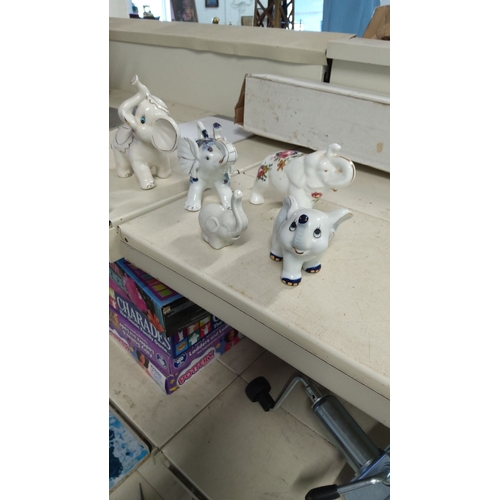 131 - Set of five vintage porcelain elephant figurines, featuring hand-painted details and floral motifs.