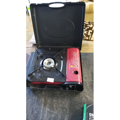 147 - Portable single-burner gas stove in a protective carrying case, featuring a compact design and easy ... 