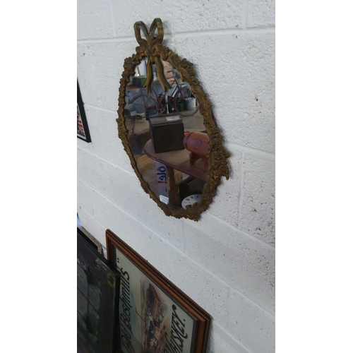 152 - Vintage gilt-framed oval mirror with ribbon crest, featuring a Rococo-style floral design.