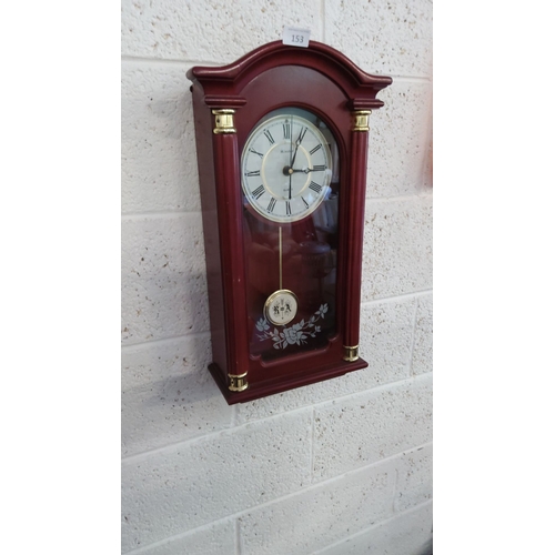 153 - Minster quartz wall clock with mahogany-tone wooden case, gold-tone accents, and floral glass panel.... 