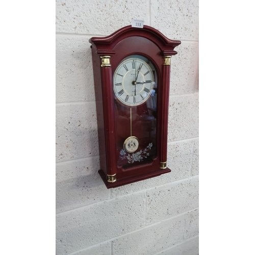 153 - Minster quartz wall clock with mahogany-tone wooden case, gold-tone accents, and floral glass panel.... 