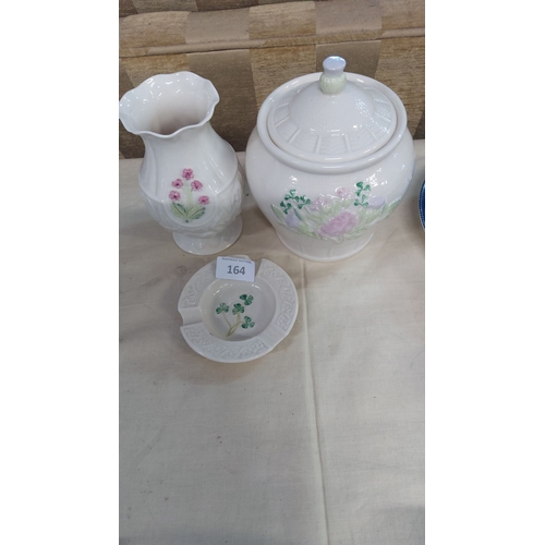 164 - Belleek Irish porcelain lot includes a lidded biscuit jar, floral vase, and shamrock ashtray. Made o... 