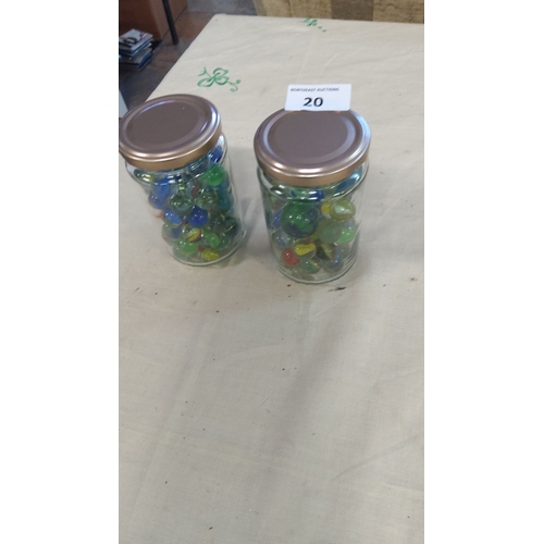 20 - Two glass jars filled with vintage glass marbles in assorted colors.