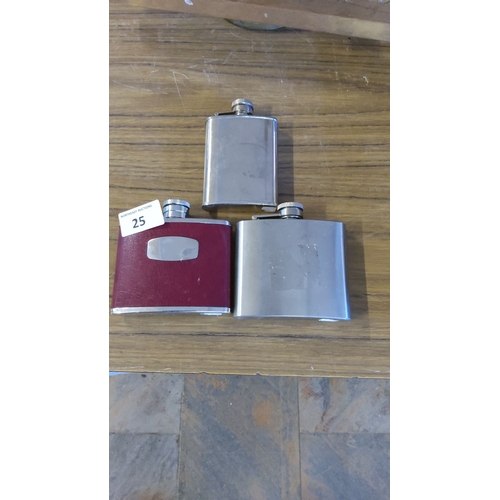 25 - Set of three stainless steel hip flasks, one with a red leatherette cover and engraved plaque.