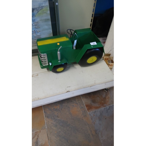 27 - Vintage green metal toy tractor planter with yellow detailing. Features oversized wheels.