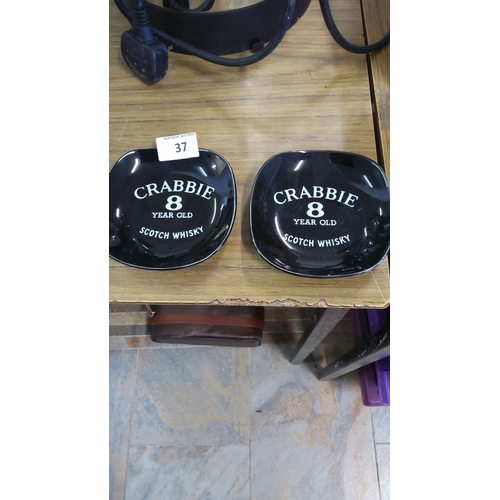 37 - Pair of vintage Crabbie 8-Year-Old Scotch Whisky ceramic ashtrays. Glossy black with bold white lett... 