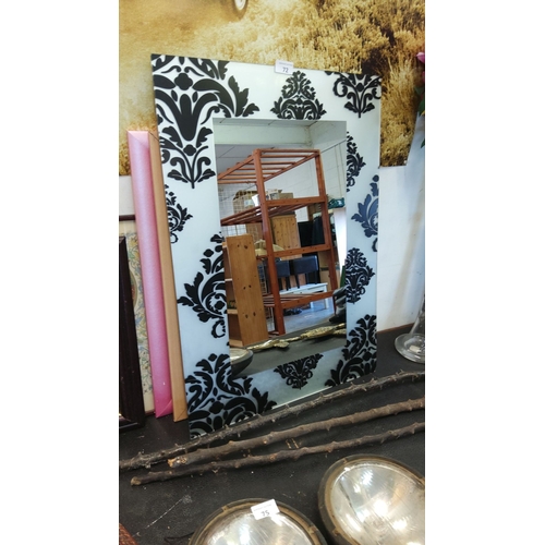 72 - Rectangular wall mirror with a black and white damask-patterned frame.