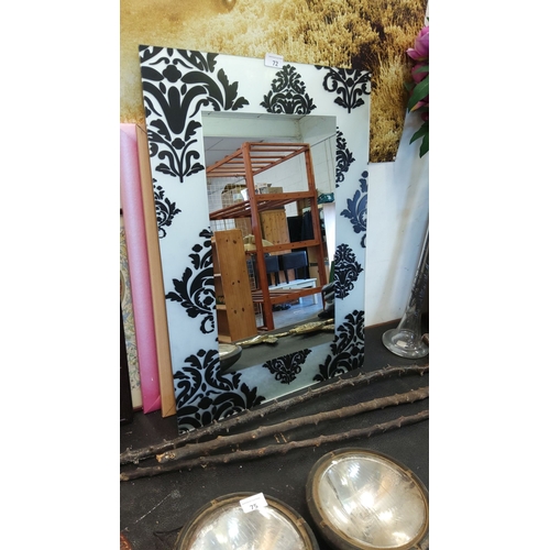 72 - Rectangular wall mirror with a black and white damask-patterned frame.