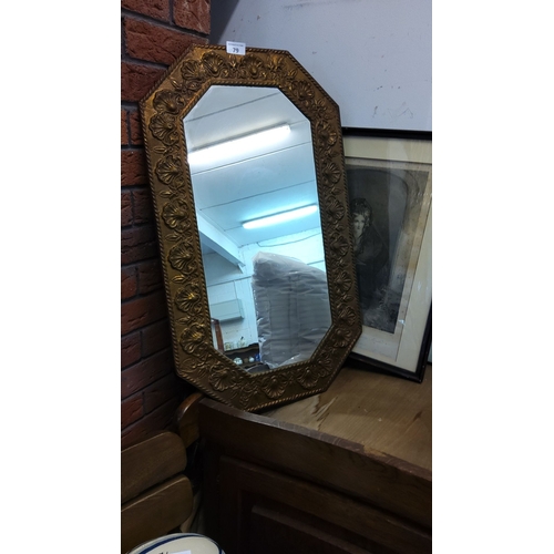 79 - Early 20th-century octagonal wall mirror with an embossed gilt-metal frame featuring floral motifs.