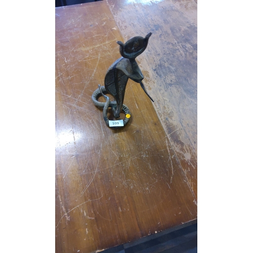 109 - Cast brass sculpture of a rearing cobra with coiled base, the hood supporting a shallow dish and a p... 