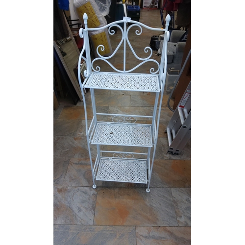 71 - White-painted wrought-iron three-tier étagère or plant stand, pierced lattice shelves beneath scroll... 