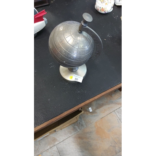 80 - Cast metal desktop terrestrial globe with engraved continental outlines and meridian arc, raised on ... 