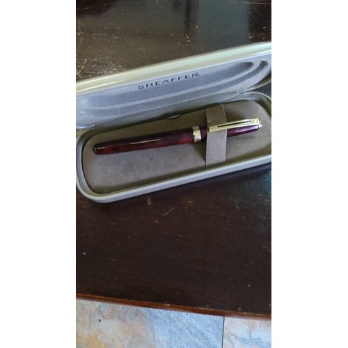 104 - Sheaffer marbled burgundy rollerball pen with gold-tone trim, presented in original branded hard cas... 